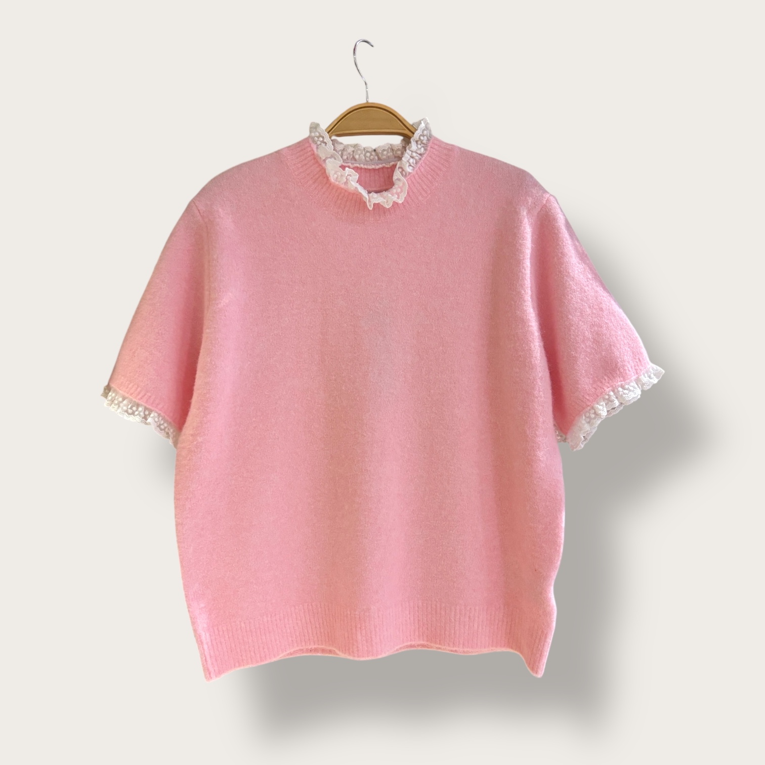 Sweter różowy z białą koronką przy dekolcie